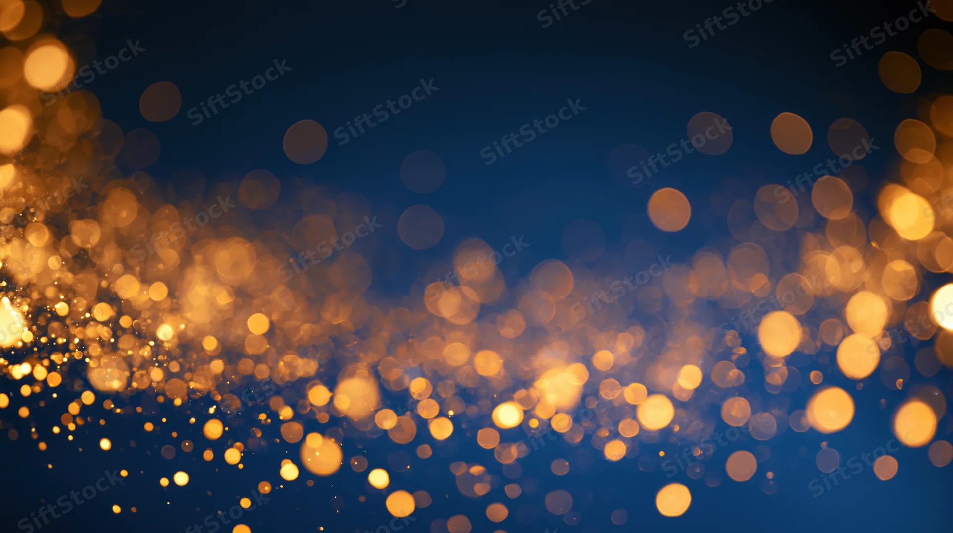 Golden bokeh lights scattered across a dark blue background with soft glow and festive ambiance