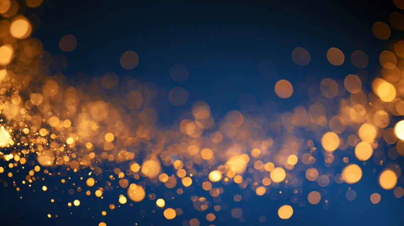 Golden bokeh lights scattered across a dark blue background with soft glow and festive ambiance