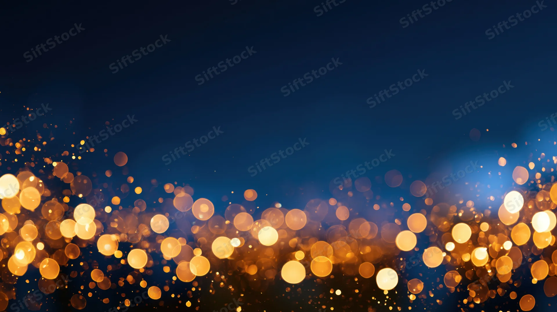 Golden bokeh lights glowing softly against a dark blue background with copyspace above