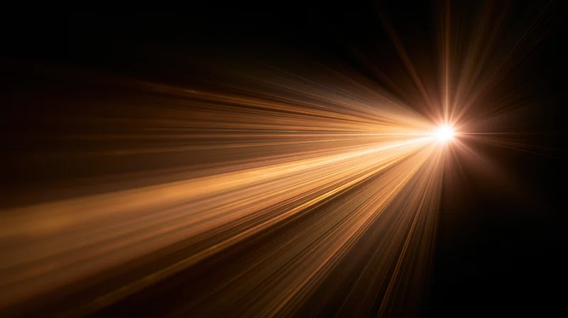 Bright golden light burst radiating from center against dark background with copyspace