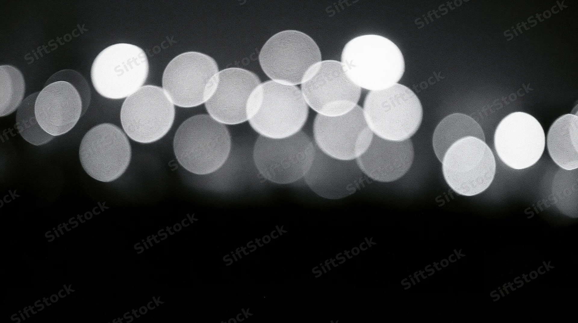 Blurred circular lights arranged in a row against a dark background