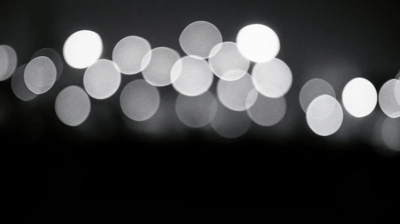 Blurred circular lights arranged in a row against a dark background