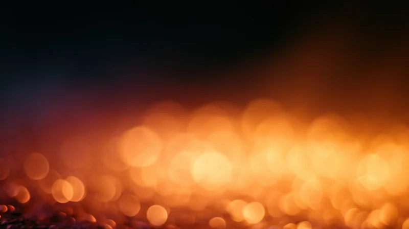 Blurred orange bokeh lights creating a warm glowing background with dark upper space for text or design