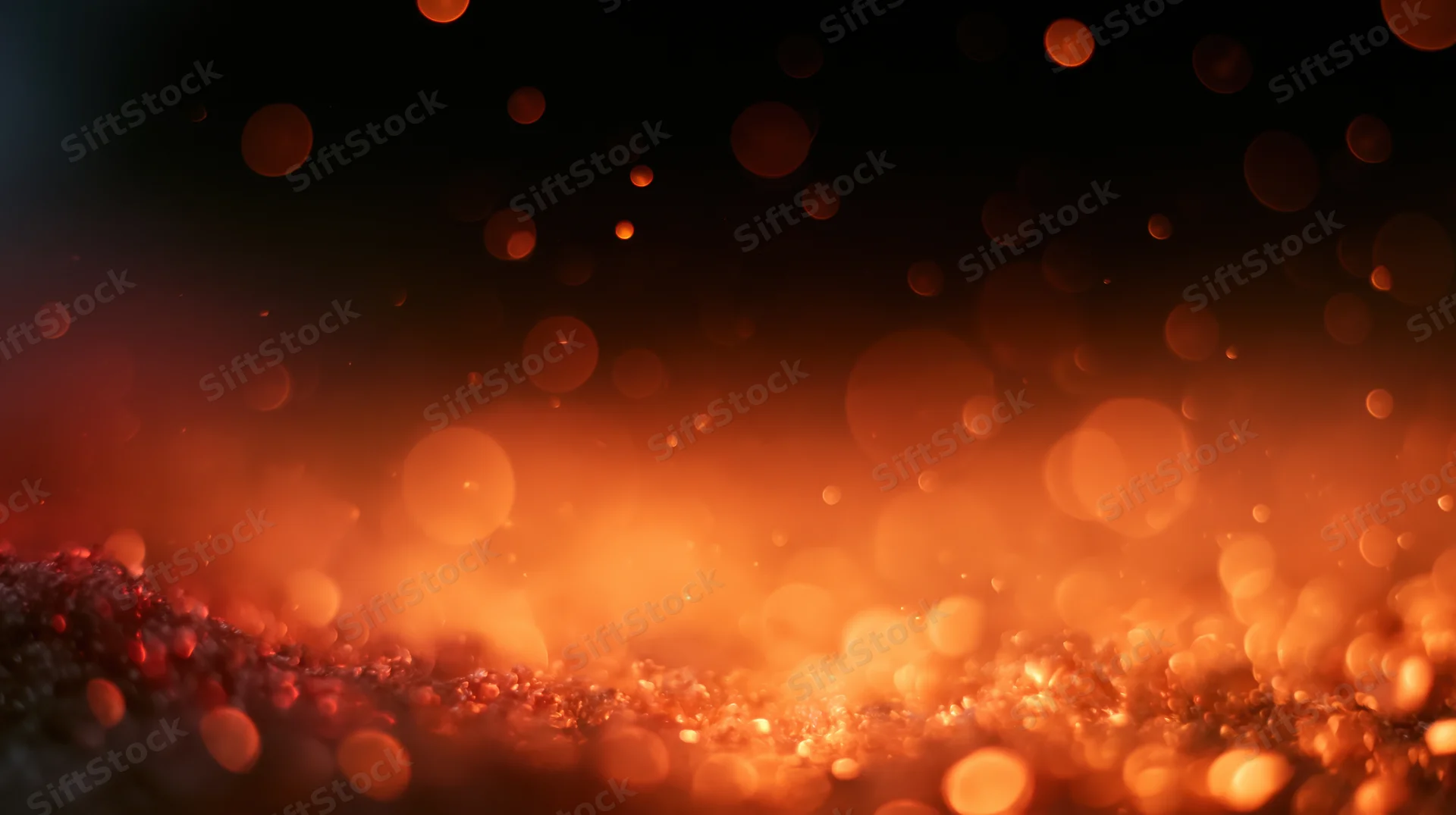 Glowing orange bokeh lights scattered across a dark textured surface with soft focus and warm ambient glow