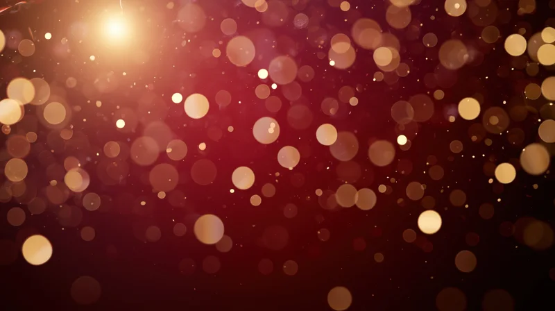 Warm glowing bokeh lights in red and gold with soft sparkle and copyspace for festive holiday background