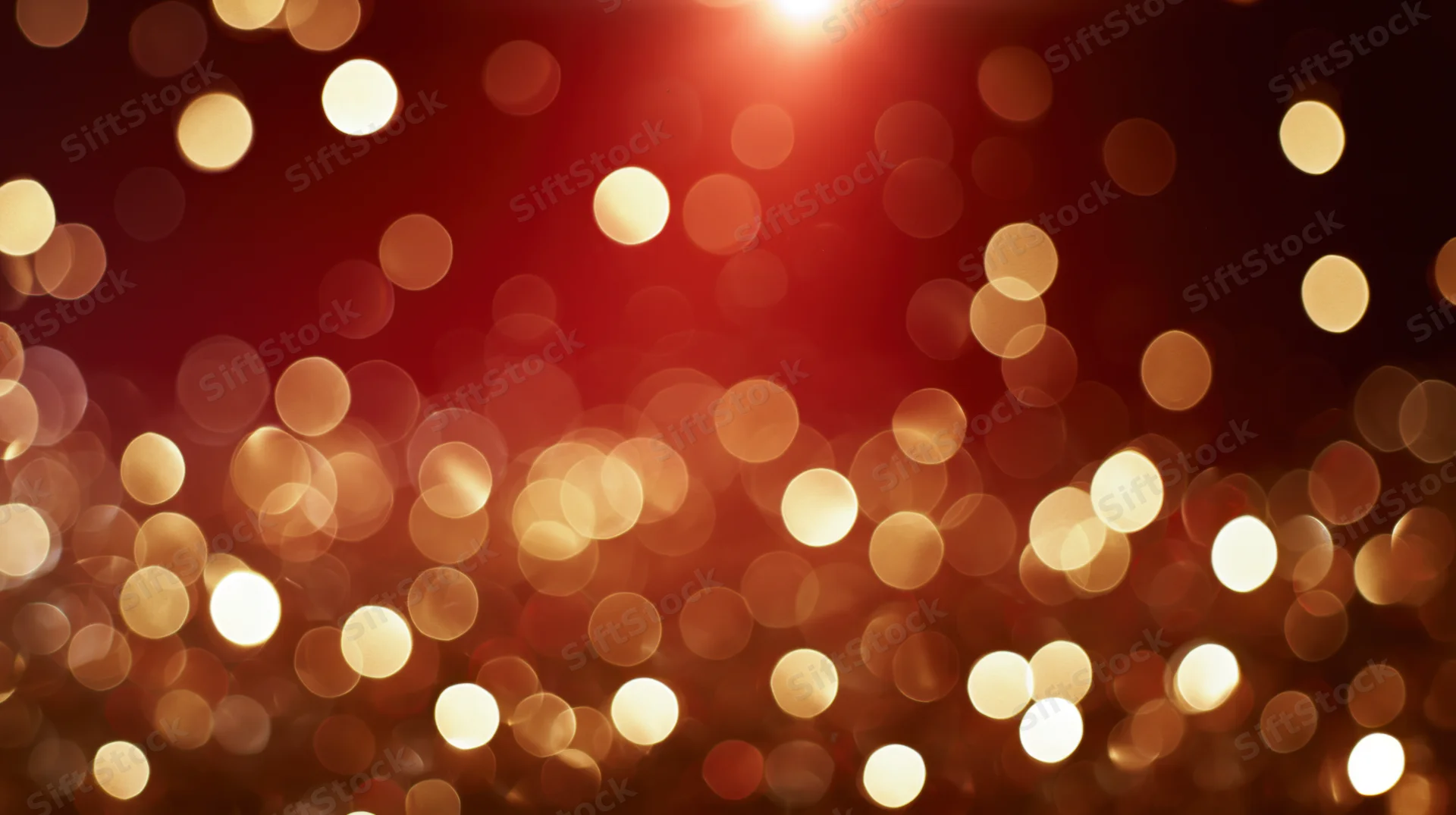 Blurred golden lights scattered across a deep red background with soft glow and bokeh effect