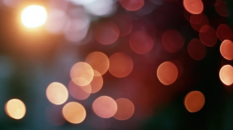 Blurred circular lights in warm tones arranged across a dark background with soft glow and bokeh effect