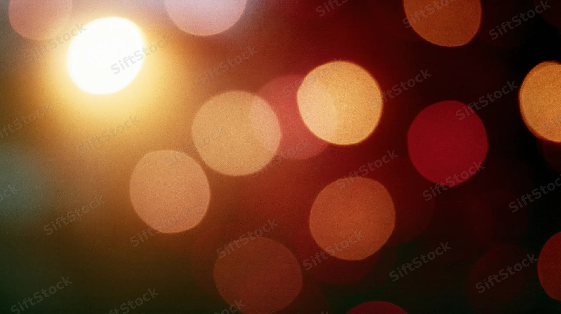 Blurred circular lights in warm tones arranged across a dark background with soft glow and bokeh effect