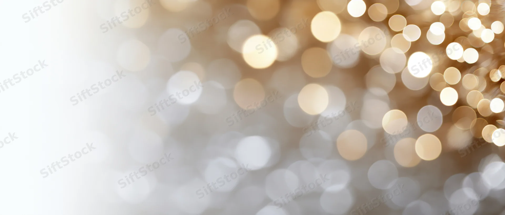 Blurred golden and white bokeh lights forming a festive background with copyspace on the left
