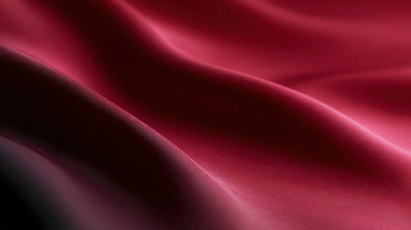 Flowing red silk fabric draped in soft folds with lustrous sheen