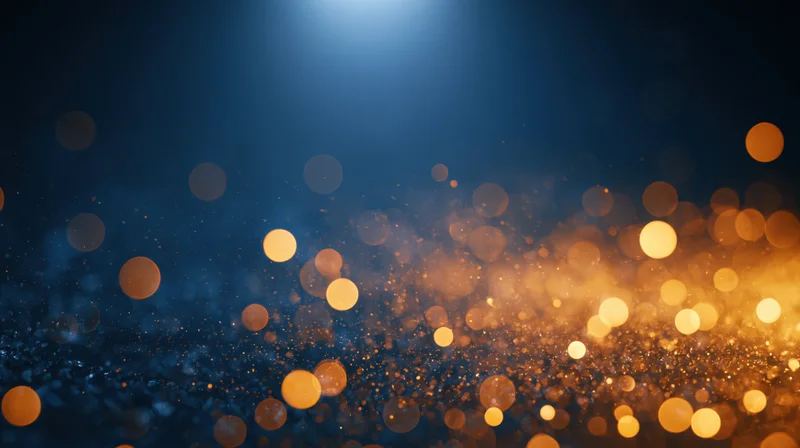 Golden bokeh lights glowing against a dark blue background with sparkling particles and soft glow