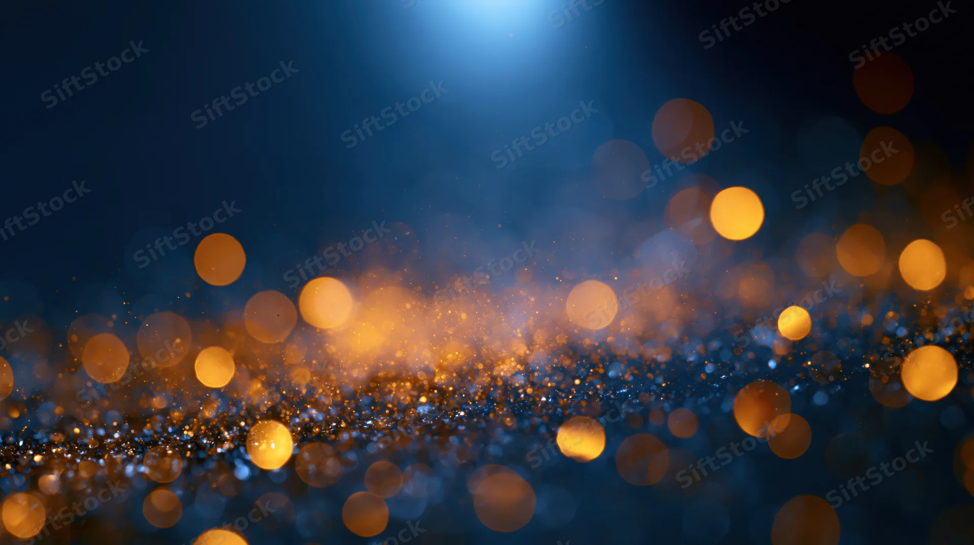Golden bokeh lights shimmering across a dark blue background with soft glow and scattered particles