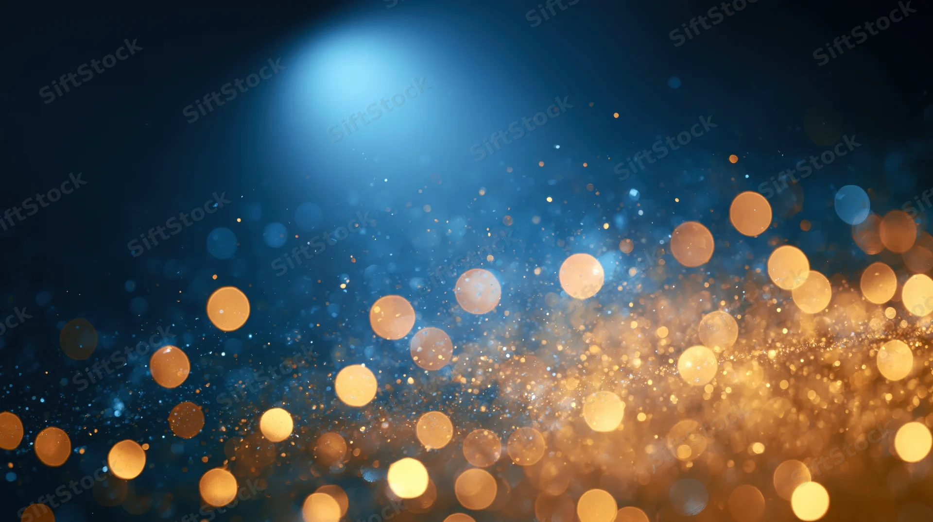 Golden bokeh lights glowing against a deep blue background with soft sparkle and depth