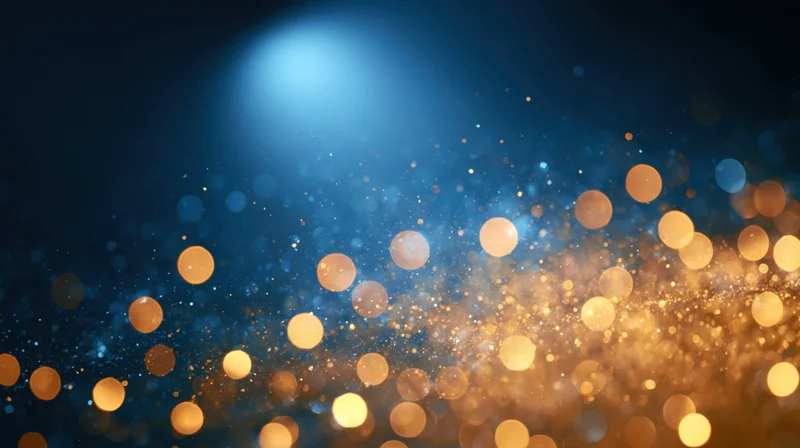Golden bokeh lights glowing against a deep blue background with soft sparkle and depth