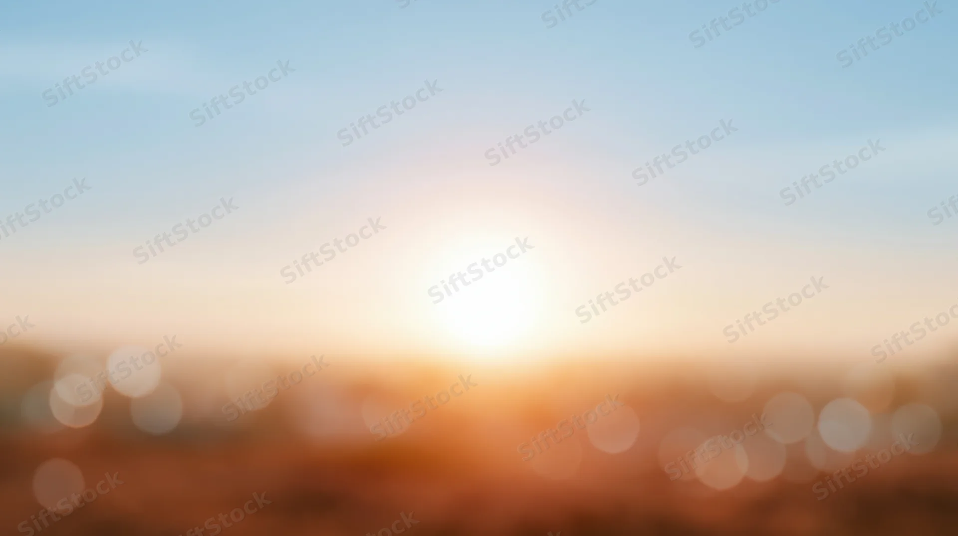 Blurred sunset over cityscape with bokeh lights and warm glow in the sky