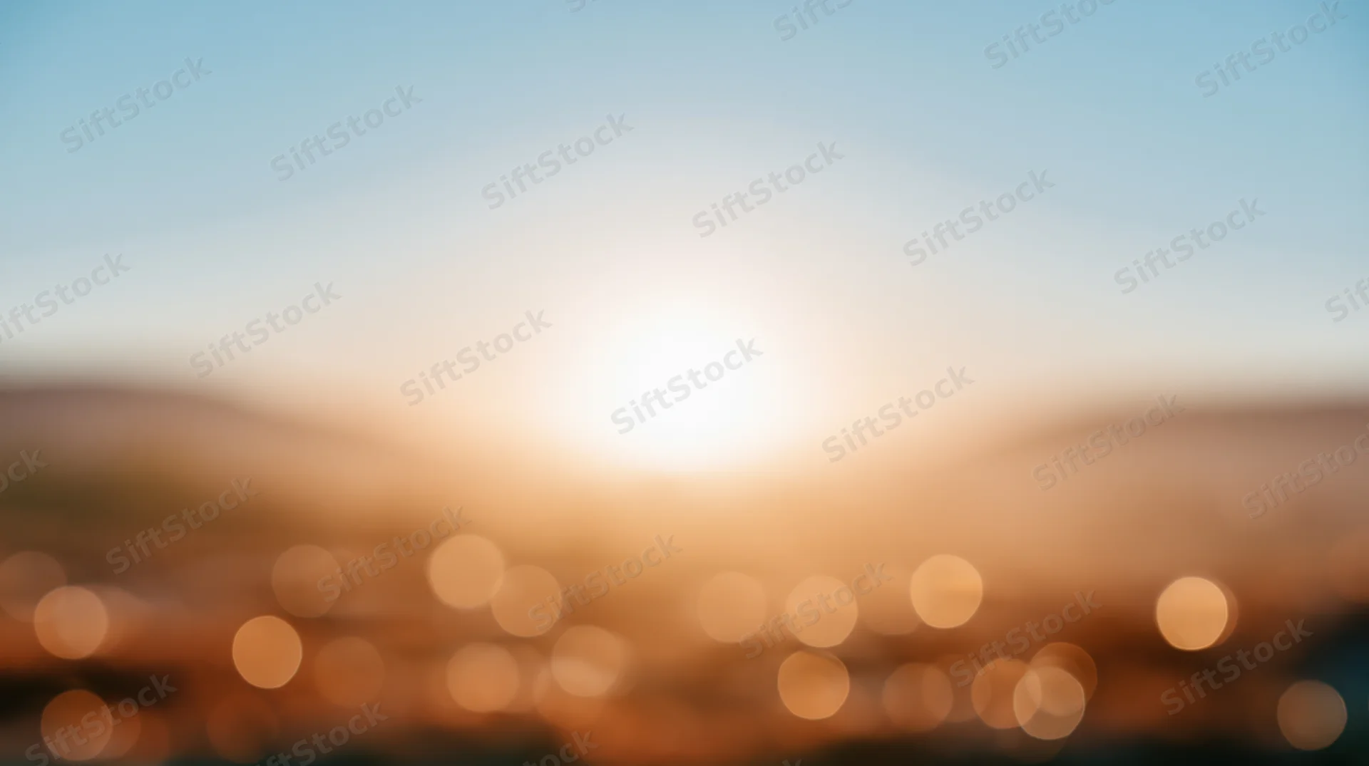 Blurred cityscape at sunset with bokeh lights and warm sky gradient