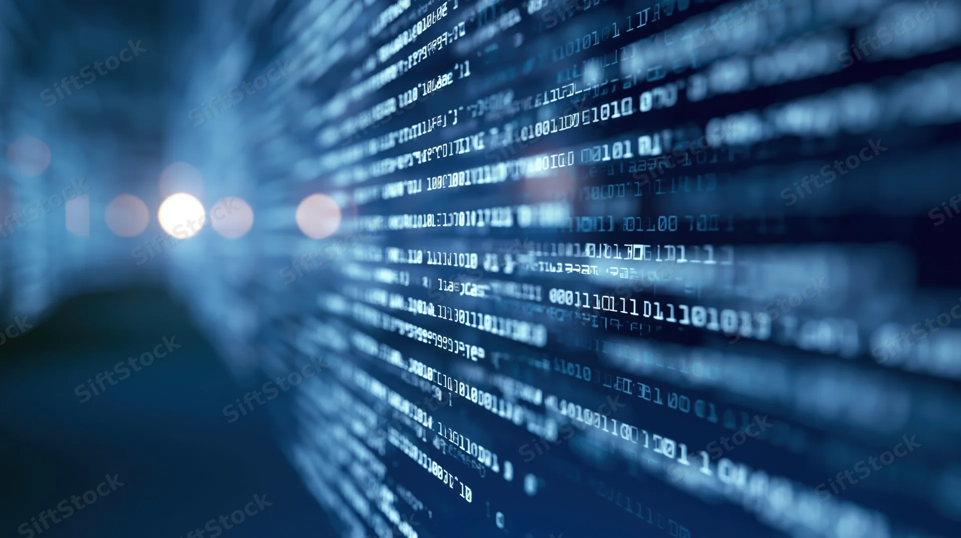 Digital code streaming across a dark screen with blurred light effects in the foreground