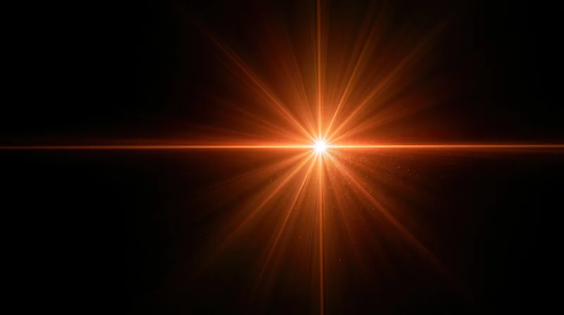 Bright orange starburst light flare radiating from center against black background