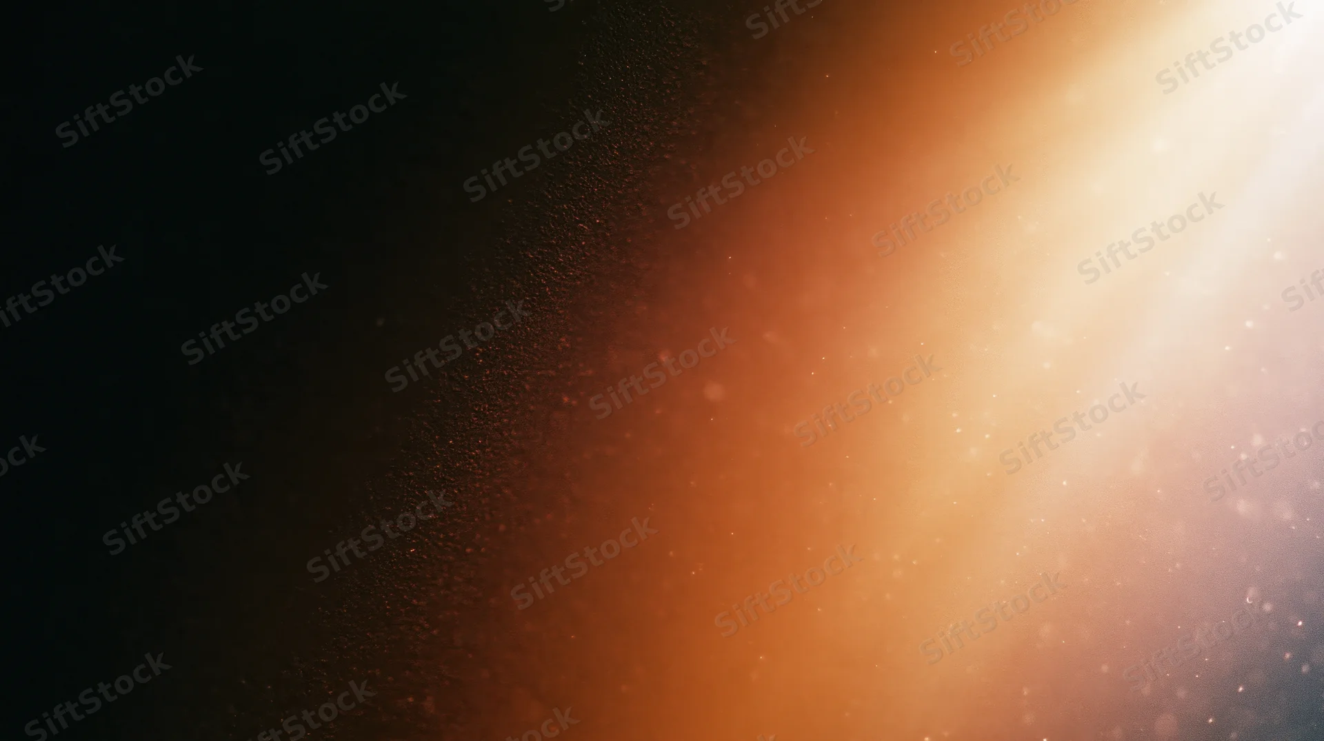 Warm glowing light radiating across a dark background with floating particles