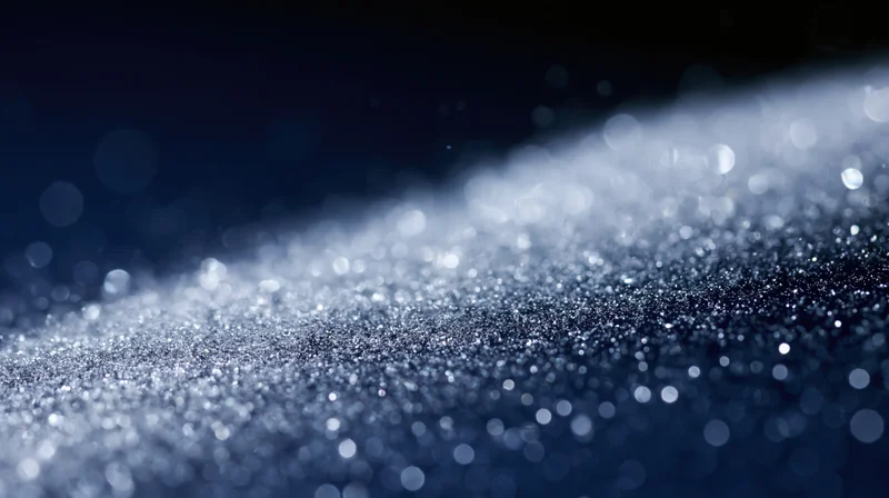 Glittering particles scattered across a dark surface with bokeh lights in the background