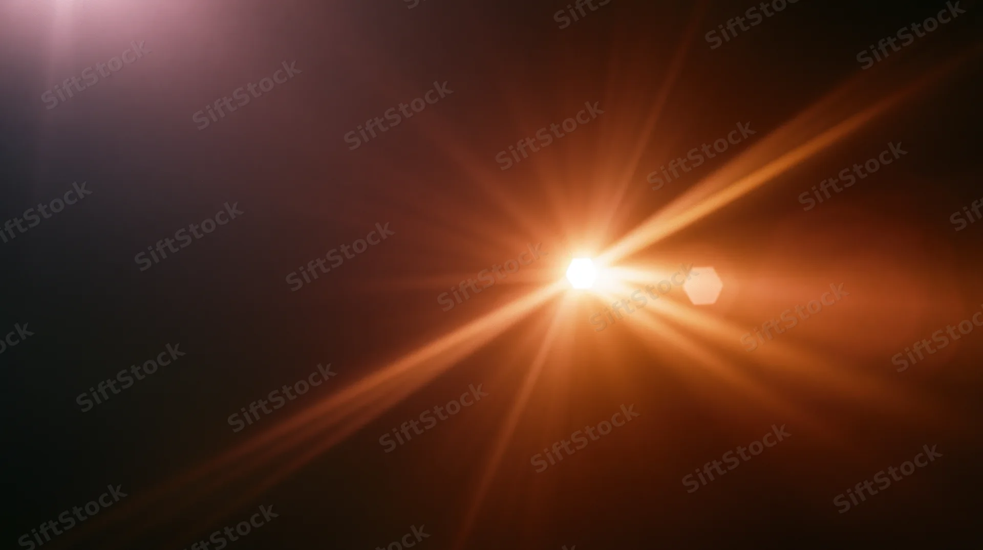 Bright light source emitting radiant beams across dark background with lens flare and bokeh effect