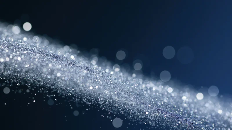 Shimmering silver glitter particles in motion against a dark blue background with bokeh lights