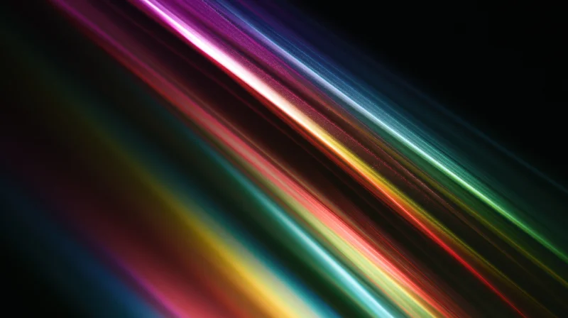 Diagonal streaks of vibrant rainbow light across a dark background