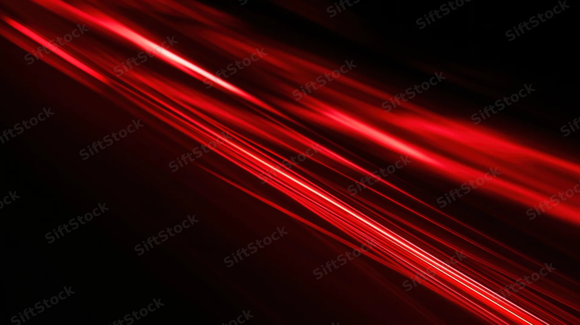Diagonal red light streaks moving across a black background with motion blur