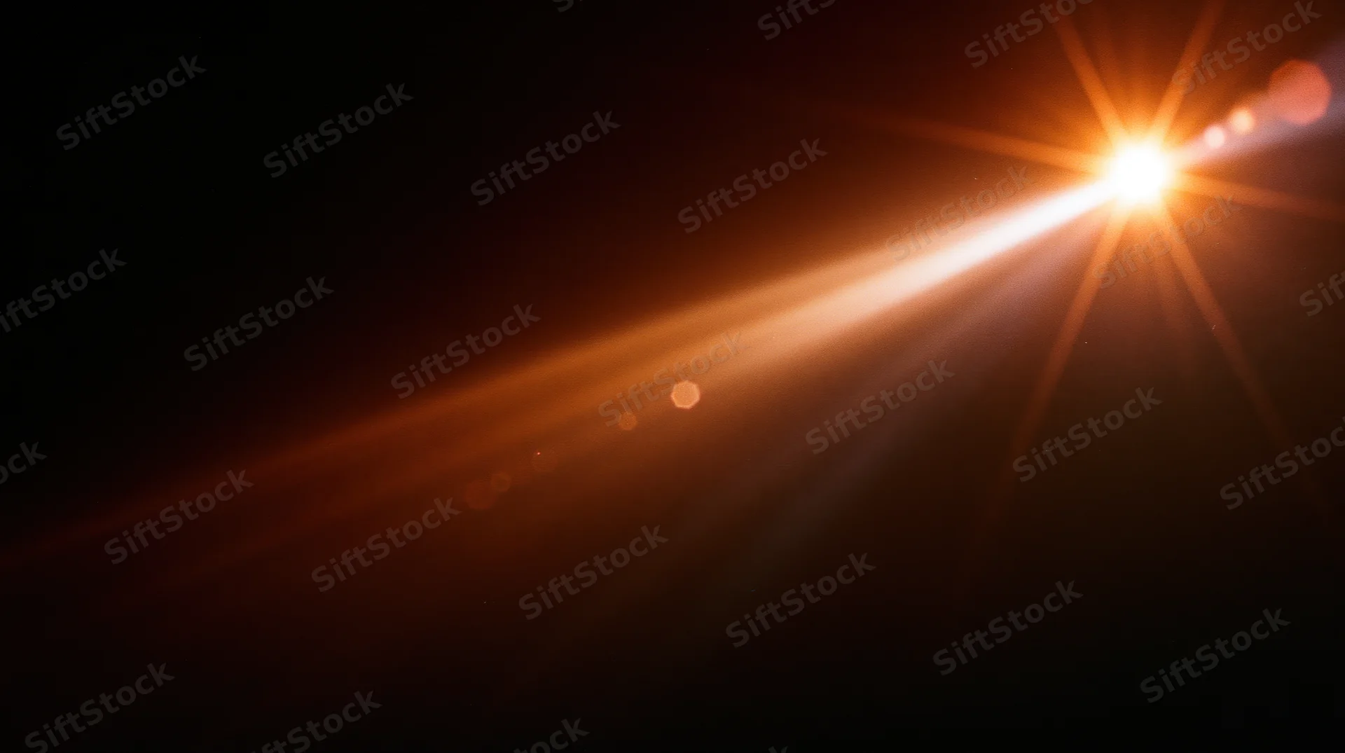 Bright orange light beam radiating from top right corner against dark background with lens flare and bokeh highlights