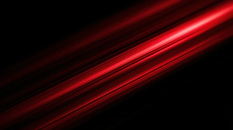 Diagonal red light streaks glowing across a black background with motion blur