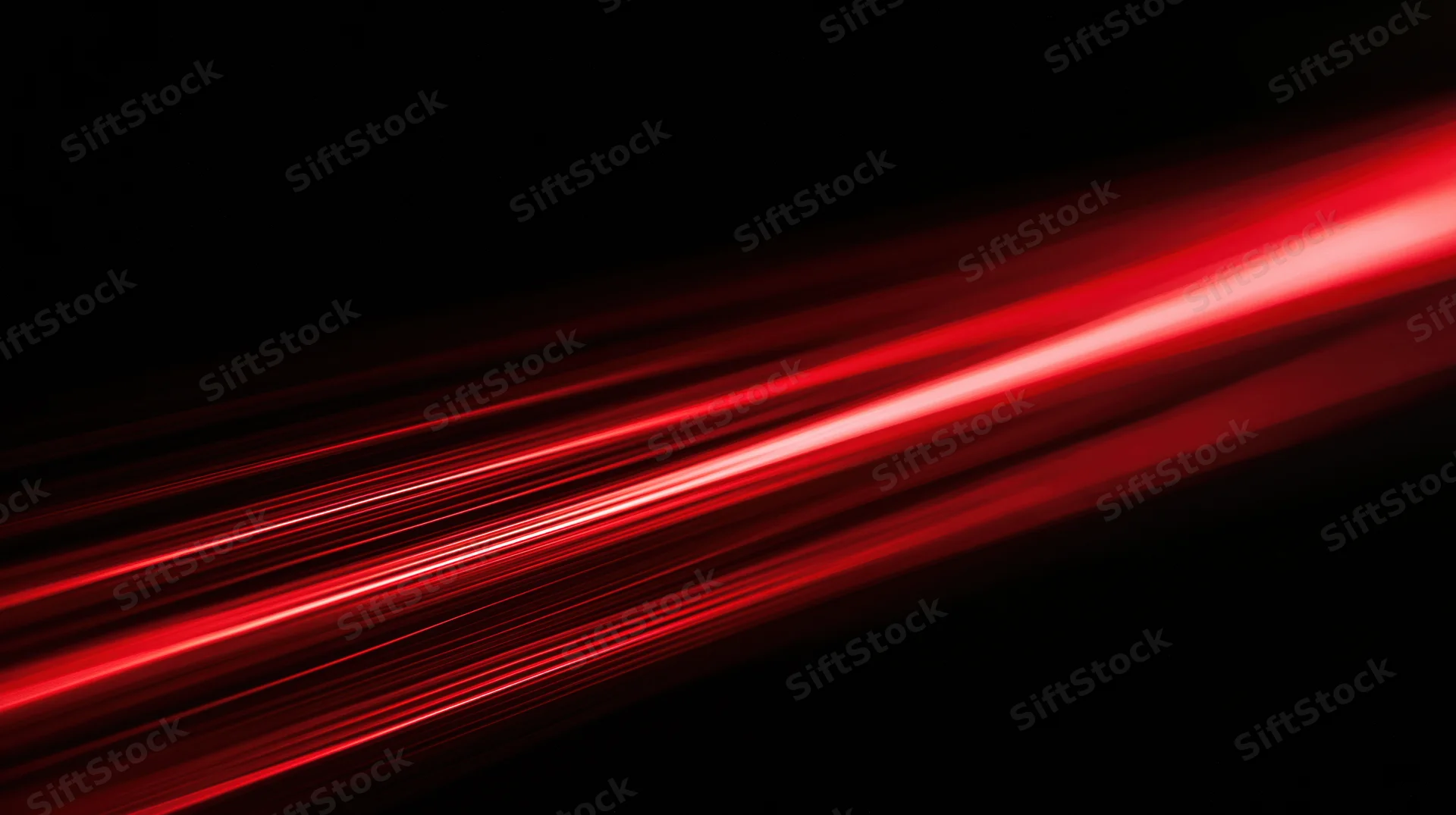 Red light streaks moving diagonally across a black background
