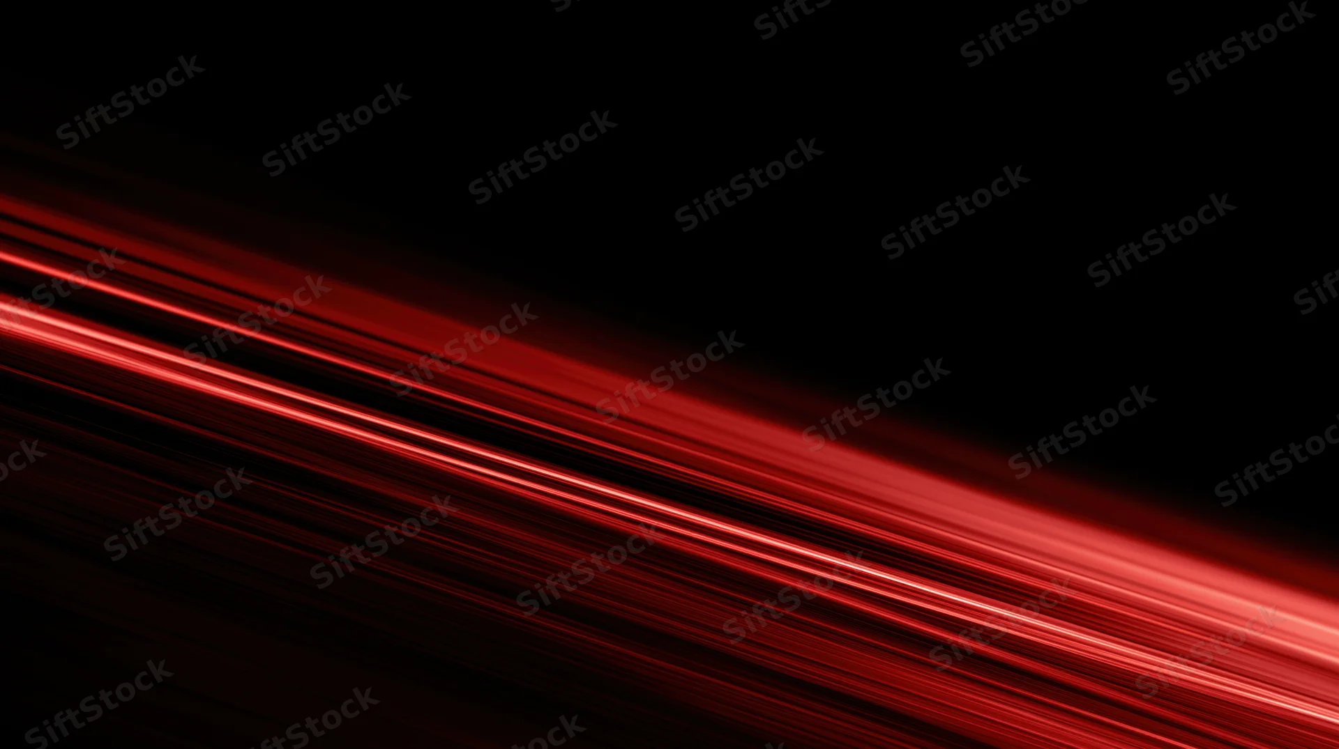 Diagonal red light streaks moving across a black background with motion blur