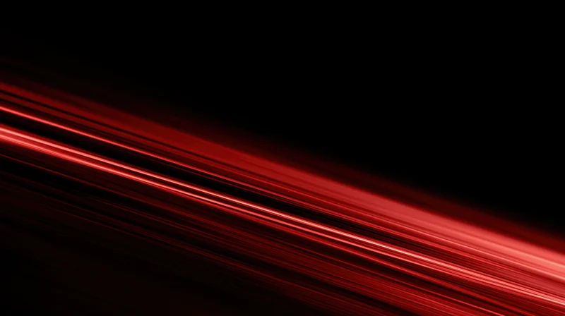 Diagonal red light streaks moving across a black background with motion blur