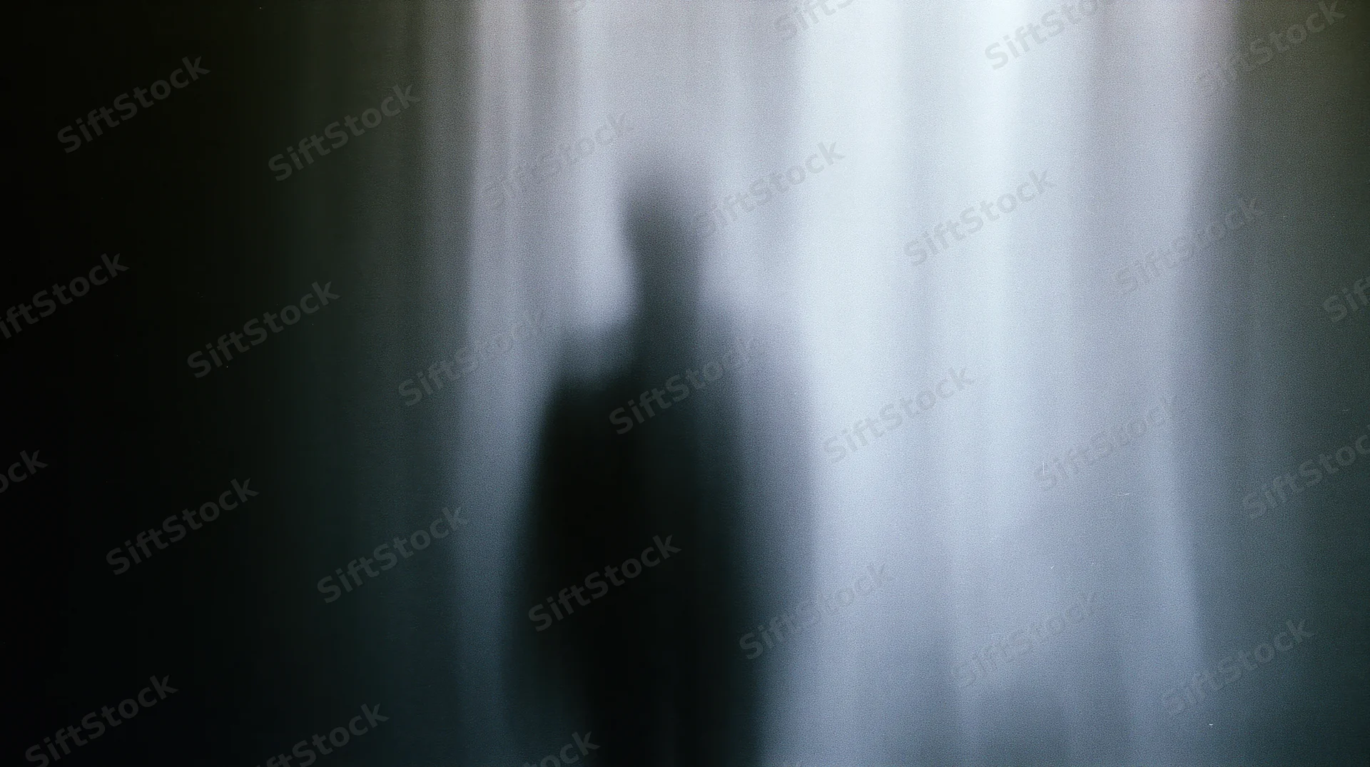 Blurred silhouette of a human figure against a vertical light gradient
