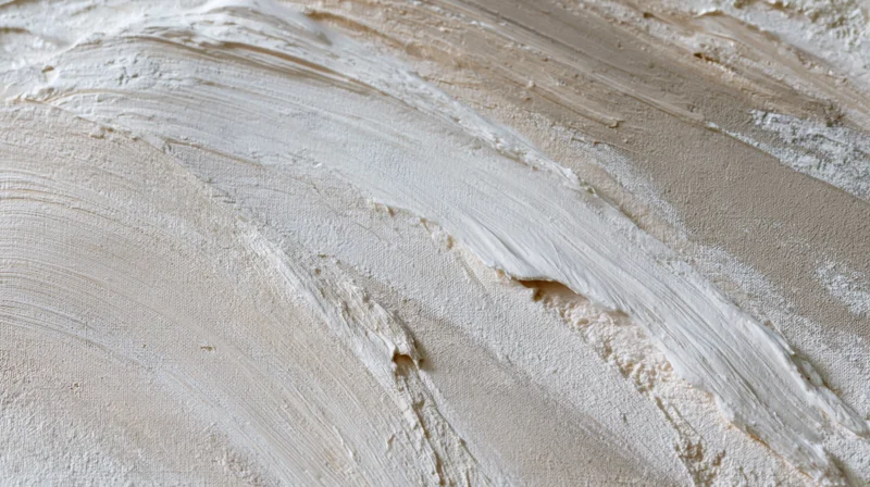 Close-up of textured plaster wall with layered brushstrokes and subtle color variations