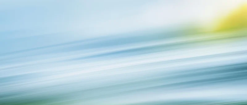 Abstract gradient background with soft blue and yellow light streaks flowing diagonally