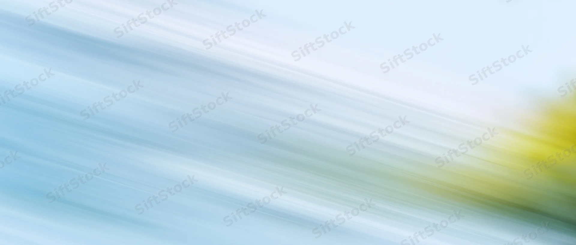 Abstract motion blur with diagonal light streaks in blue white and yellow gradient