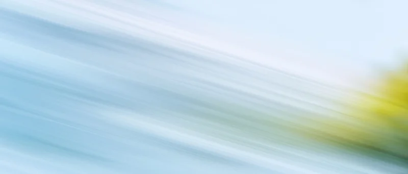 Abstract motion blur with diagonal light streaks in blue white and yellow gradient