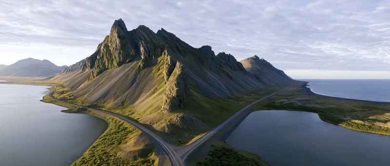 Mountain range with winding road along coastal fjord in Iceland