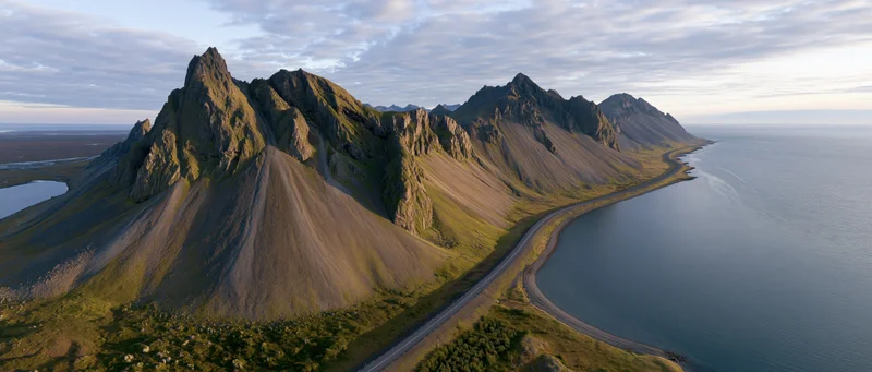 Rugged mountain peaks along a coastal road in Norway at sunset