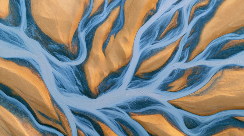 Aerial view of branching blue rivers flowing through orange desert terrain