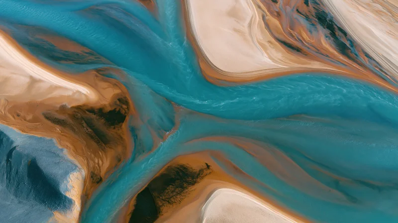Aerial view of a winding blue river flowing through sandy desert terrain
