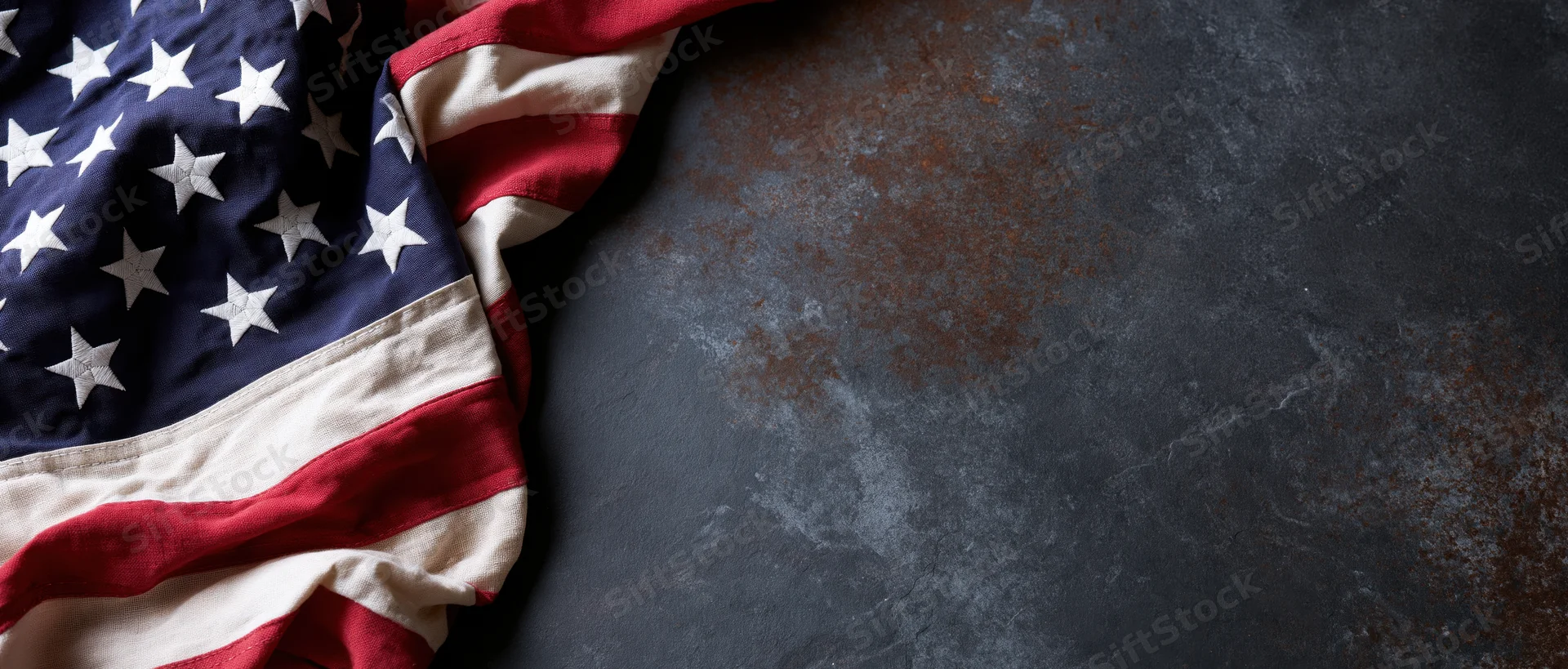 American flag draped on dark textured surface with copyspace