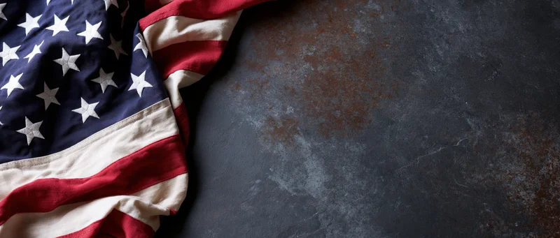 American flag draped on dark textured surface with copyspace