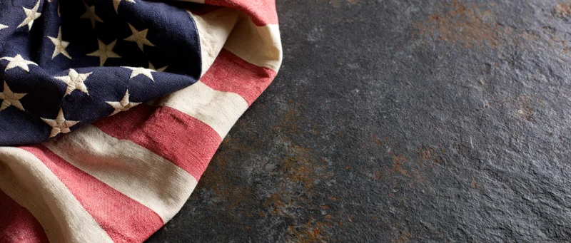American flag draped on dark textured surface with copyspace