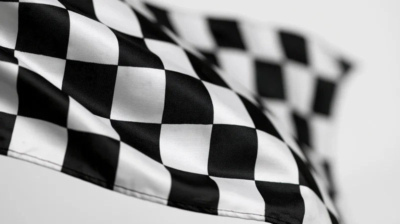 Checkered flag waving in the wind against a plain white background