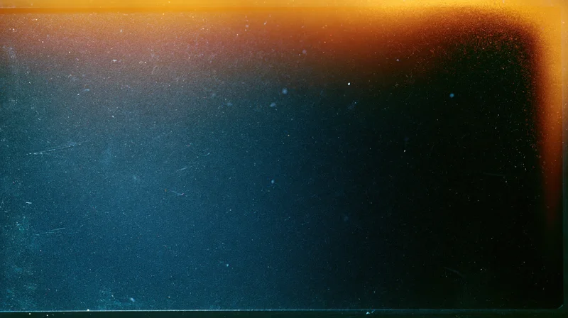 Abstract gradient transitioning from orange to dark blue with visible film grain and surface imperfections