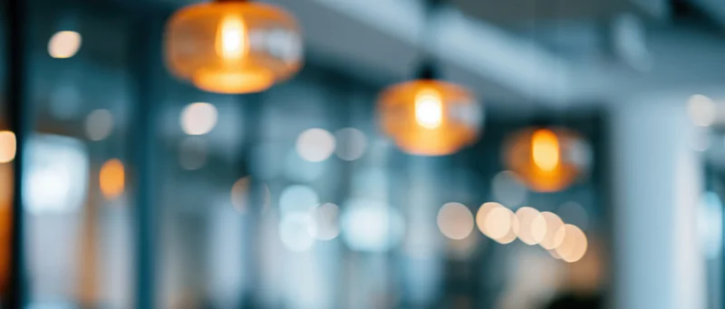 Blurred interior view with hanging warm lights creating soft glow in modern office space