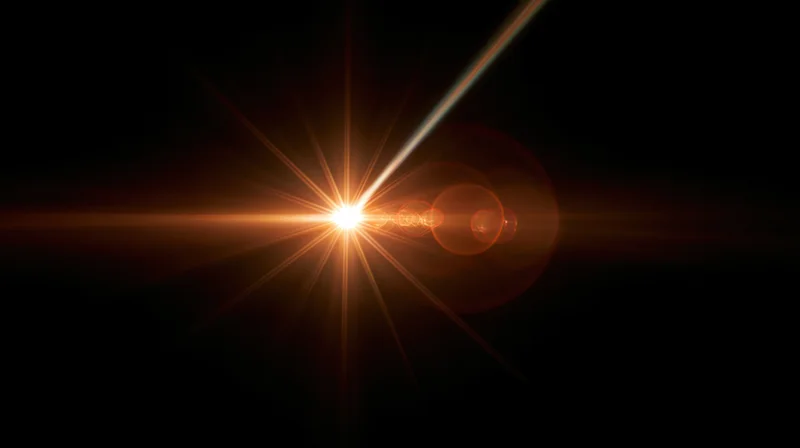 Bright orange light burst with lens flare and starburst effect on dark background