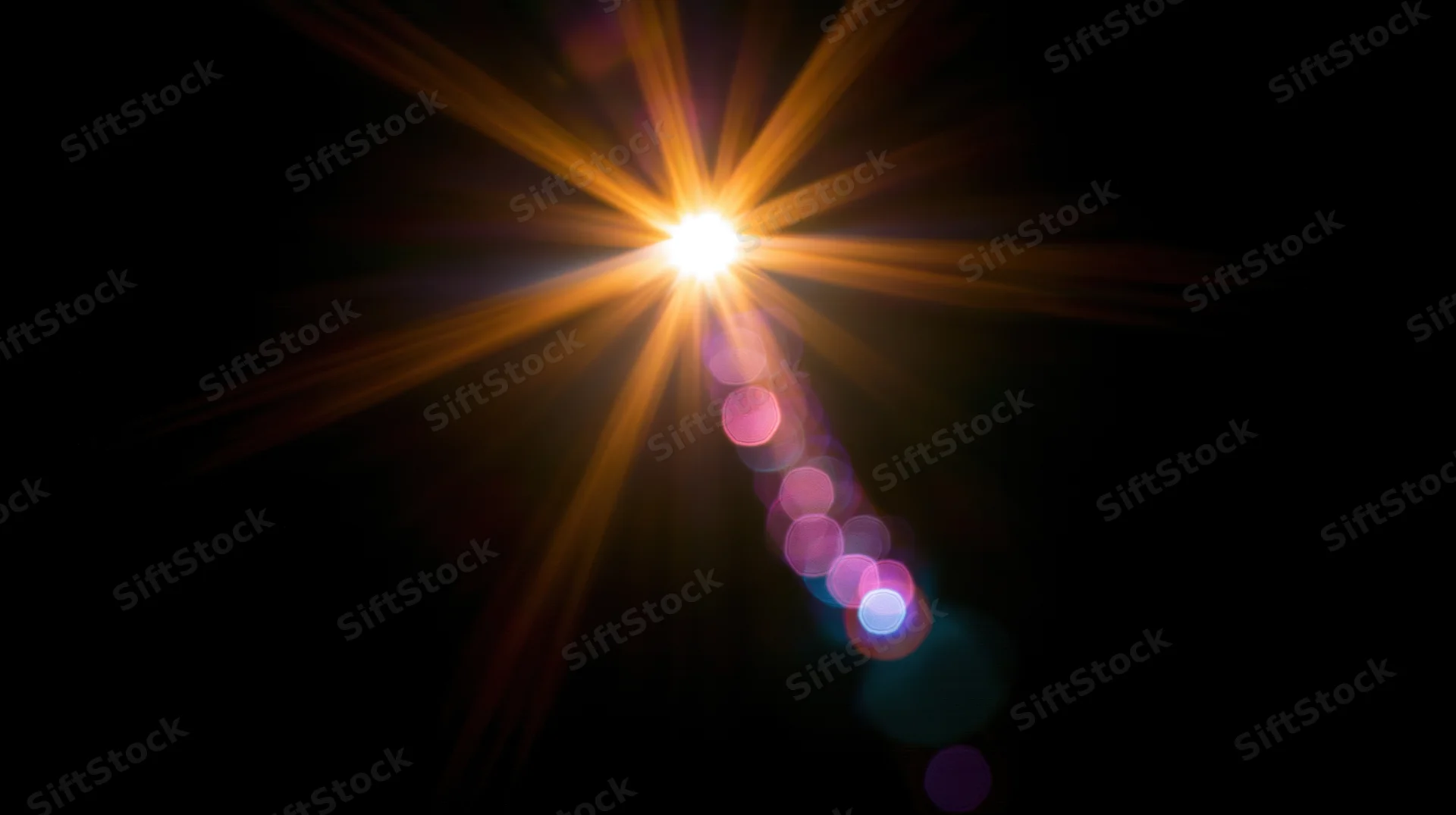 Bright starburst light with colorful bokeh trails on dark background